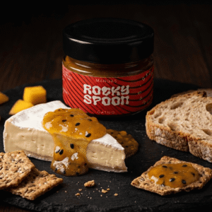 Rocky Spoon mango čatnis patiekiamas su sūriu ir krekeriais ant tamsaus fono / Rocky Spoon mango chutney served with cheese and crackers on dark background gourmet food photo